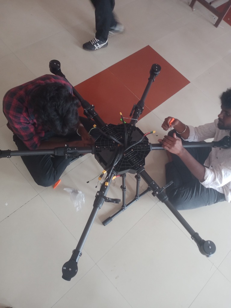 Two drone builders working on central flight controller assembly wiring