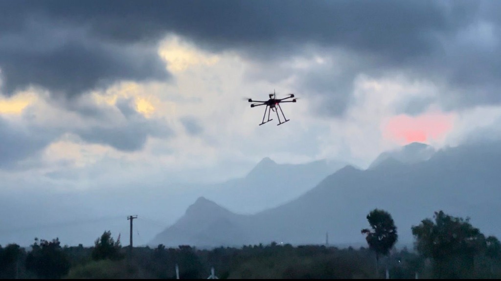 Quadcopter drone performing high-altitude autopilot testing in front of mountain range